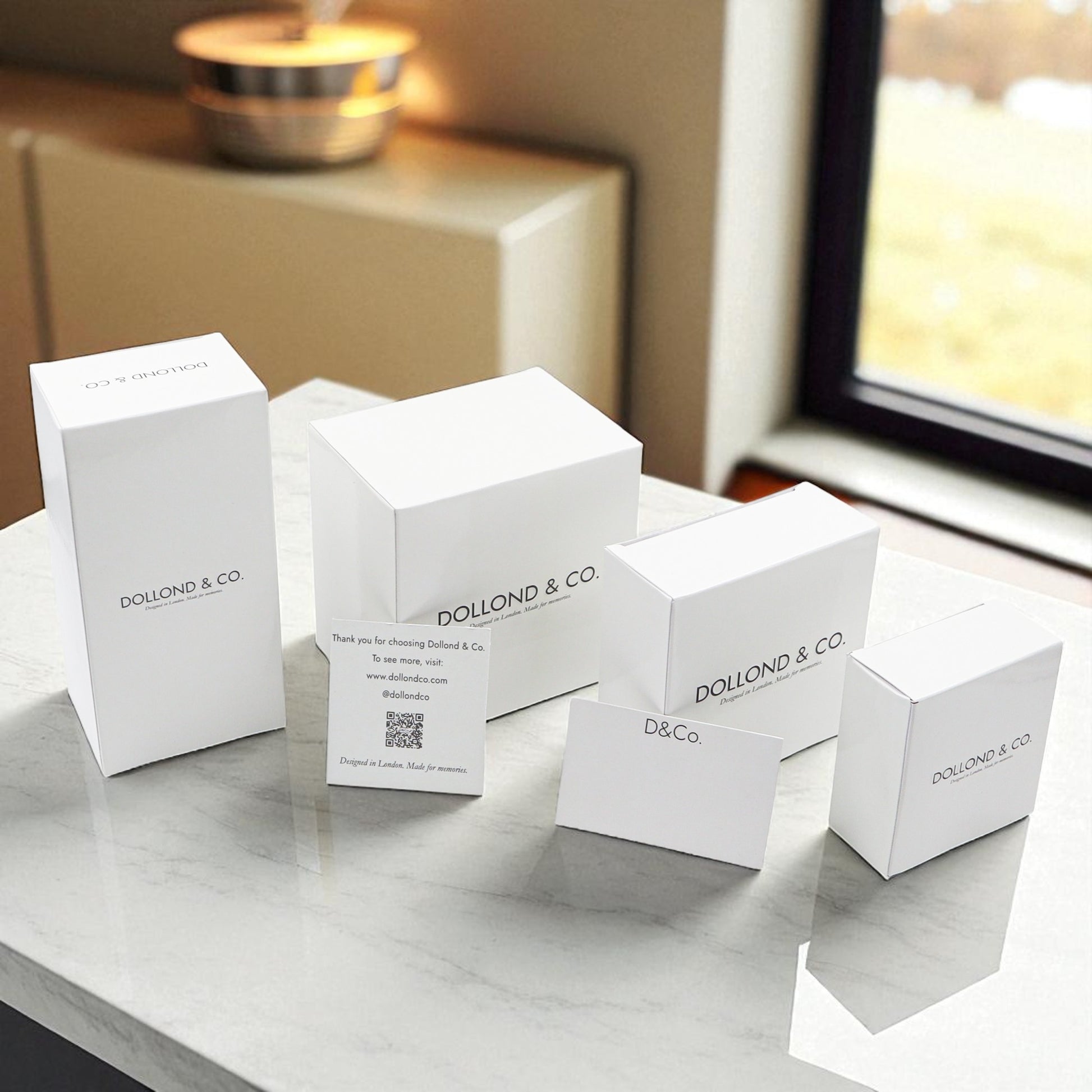 White boxes with 'Dollond & Co' branding on a marble surface.