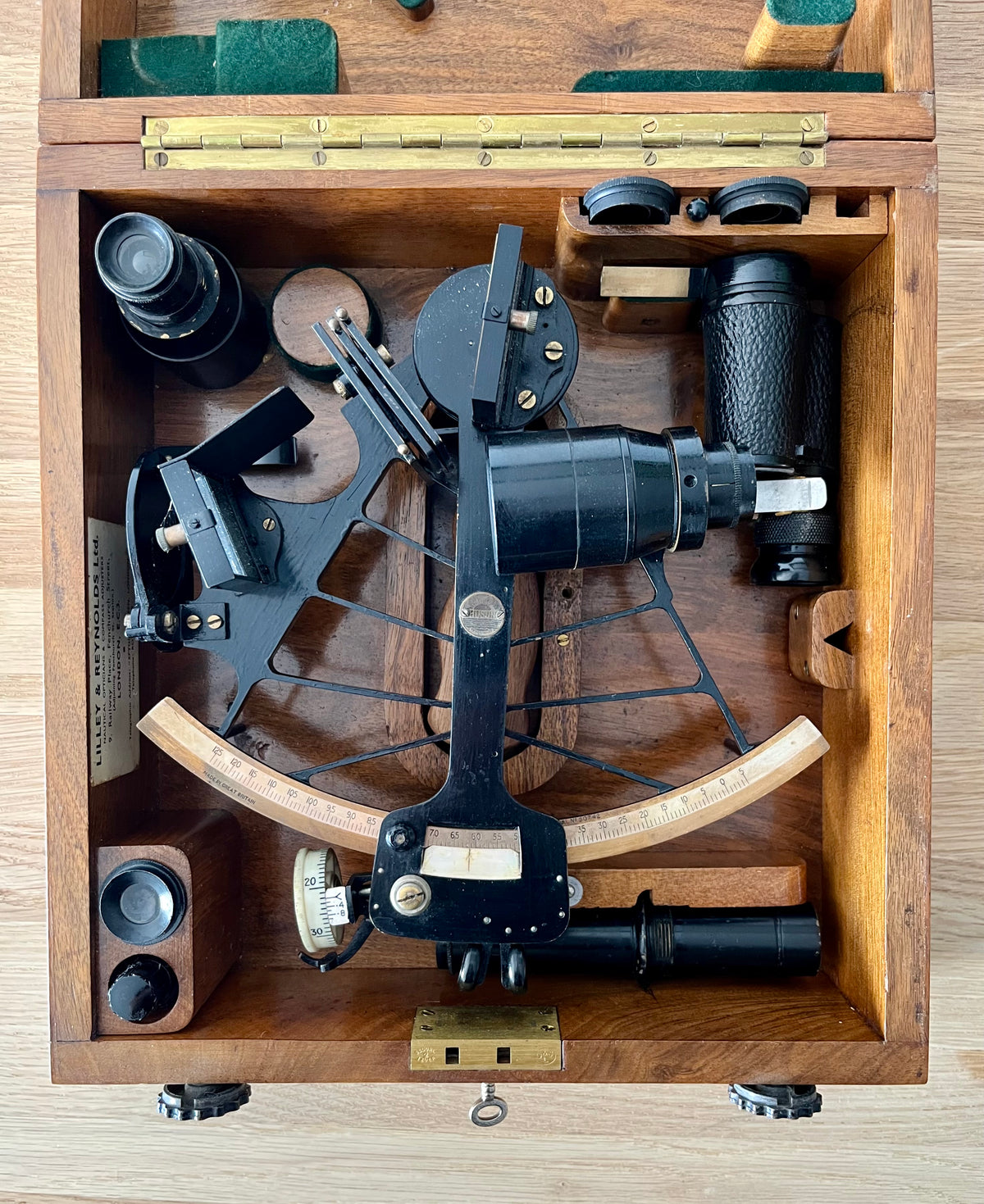 Vintage sextant in a wooden box on a light wood surface
